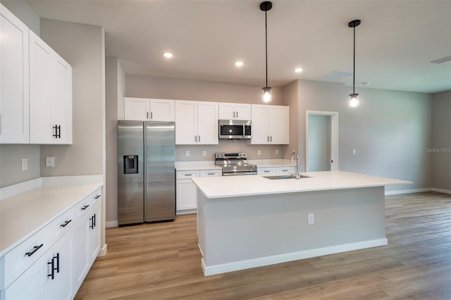 9987 SW 39th Ter, Ocala, FL 34476 - kitchen featuring appliances with stainless steel finishes, light wood finished floors, white cabinets, light countertops, and hanging light fixtures
