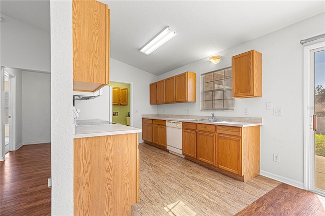 kitchen with lofted ceiling, light countertops, white dishwasher, and light wood finished floors