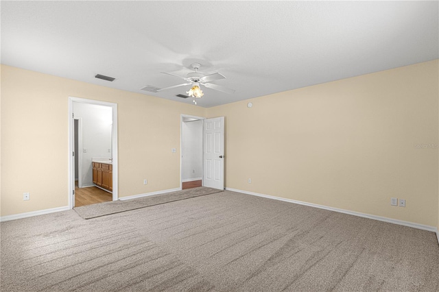 unfurnished bedroom featuring a ceiling fan, light colored carpet, visible vents, and baseboards