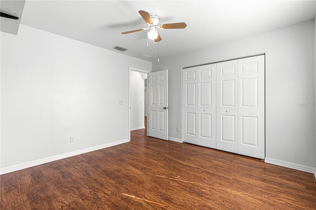 unfurnished bedroom with a ceiling fan, visible vents, baseboards, a closet, and dark wood finished floors