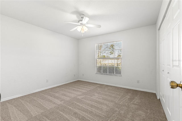 spare room featuring ceiling fan, a textured ceiling, carpet flooring, and baseboards