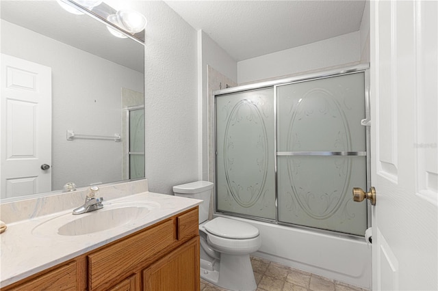 bathroom with toilet, combined bath / shower with glass door, a textured ceiling, and vanity