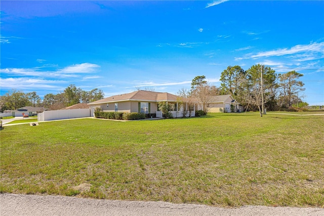 view of front facade featuring a front yard and fence