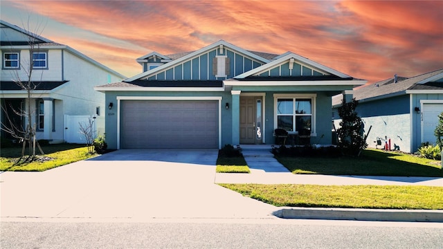 view of front of home with a garage, concrete driveway, a lawn, and board and batten siding