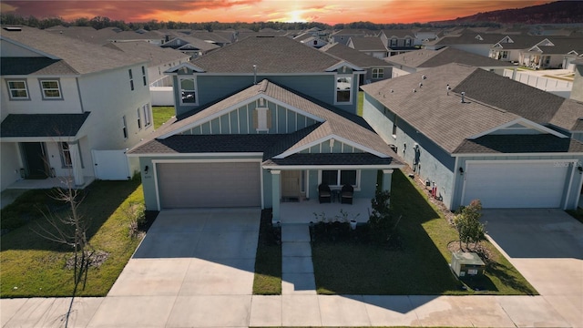 view of front of house with concrete driveway, a shingled roof, and a residential view