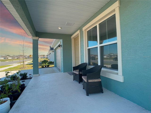 view of patio featuring an attached garage and concrete driveway