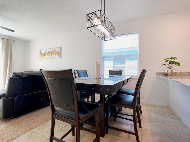 dining room featuring light tile patterned floors, a notable chandelier, baseboards, and a textured ceiling