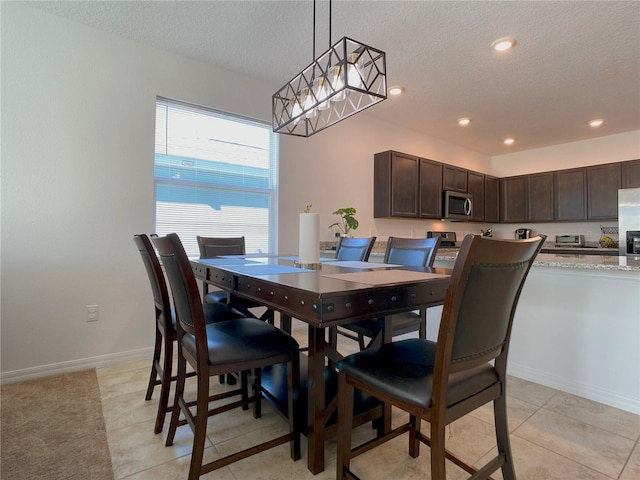 dining space featuring a textured ceiling, recessed lighting, light tile patterned flooring, and baseboards