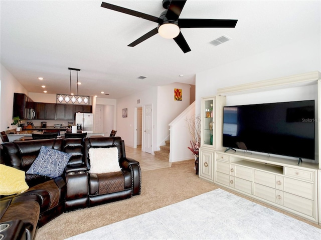 living area featuring ceiling fan, recessed lighting, light carpet, visible vents, and stairs