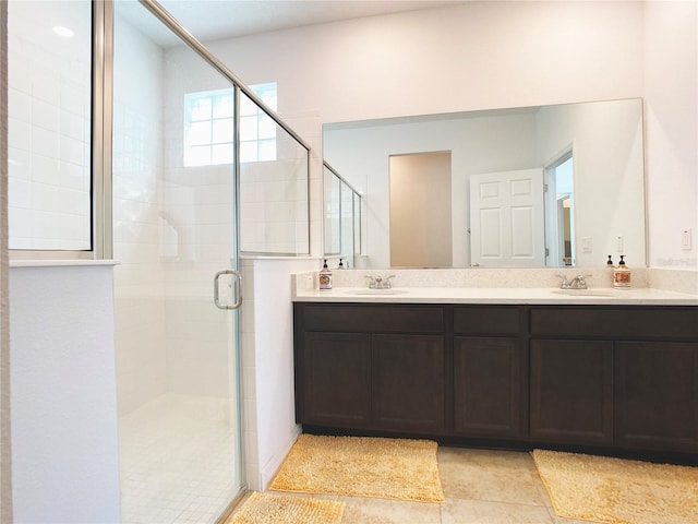 full bath featuring tile patterned flooring, a sink, a shower stall, and double vanity