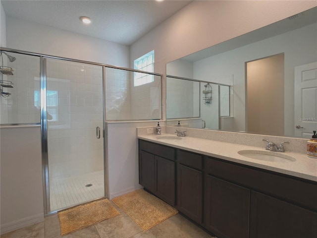 full bath featuring a stall shower, tile patterned floors, a sink, and double vanity