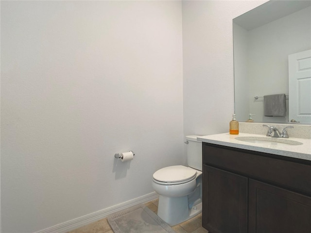 half bath featuring tile patterned flooring, baseboards, vanity, and toilet