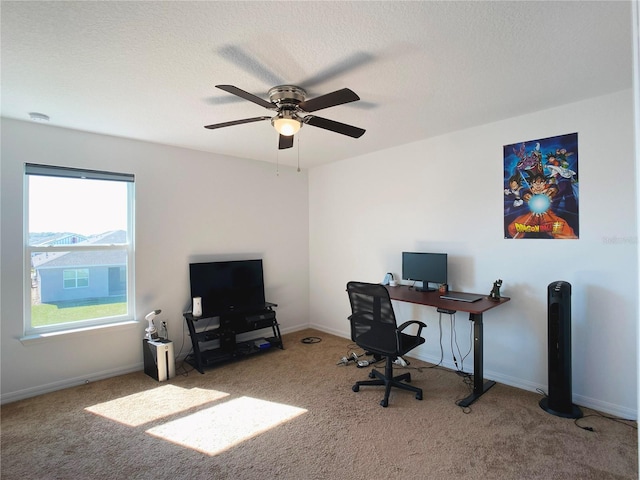 carpeted office featuring a textured ceiling, ceiling fan, and baseboards