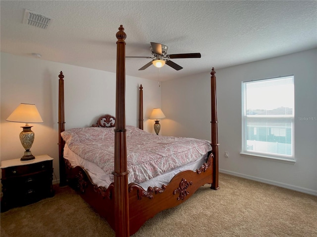 bedroom with carpet floors, visible vents, ceiling fan, and a textured ceiling