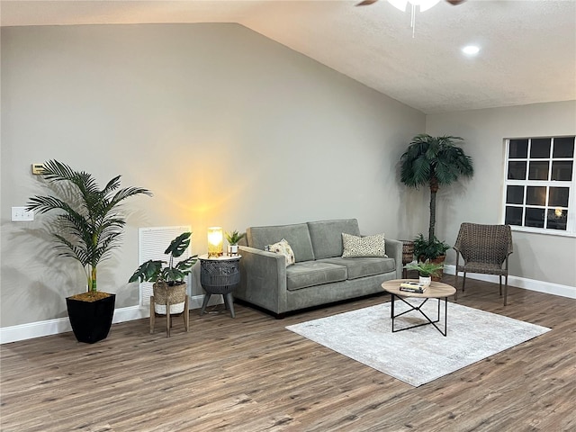 living area featuring ceiling fan, baseboards, vaulted ceiling, and wood finished floors