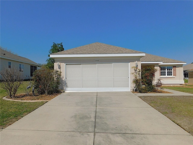 ranch-style home featuring a garage, roof with shingles, driveway, and stucco siding