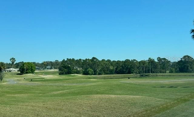 view of property's community with golf course view and a yard