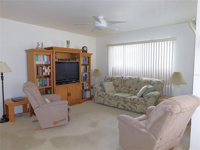 living area featuring light carpet and a ceiling fan