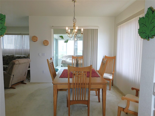 dining space with a chandelier and carpet flooring