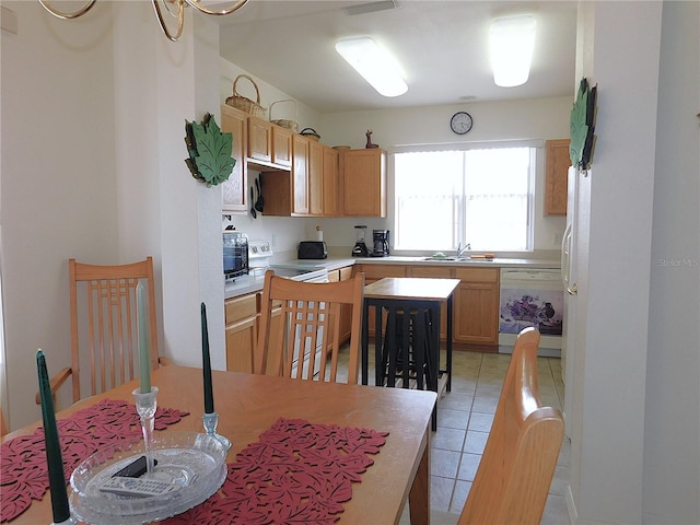 kitchen featuring white appliances, light tile patterned floors, light countertops, and a sink