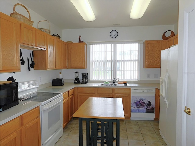 kitchen featuring light tile patterned floors, light countertops, white appliances, and a sink