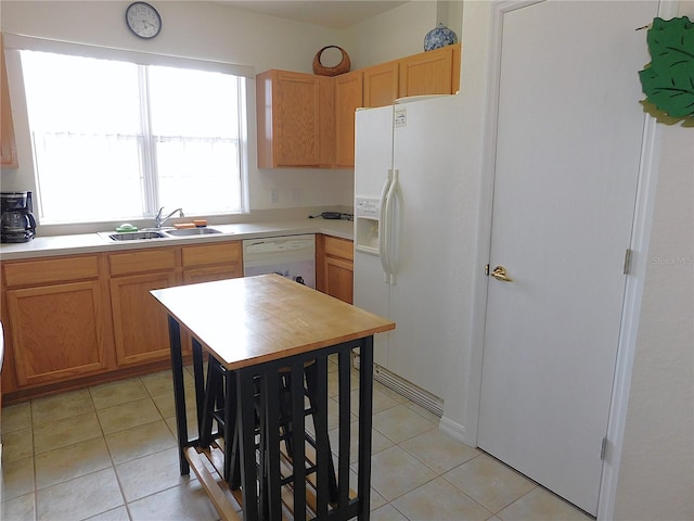 kitchen featuring light countertops, a sink, white dishwasher, and light tile patterned floors