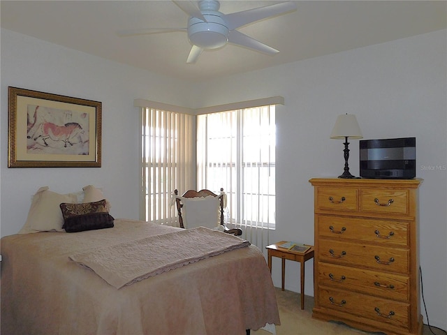 bedroom with a ceiling fan and light colored carpet