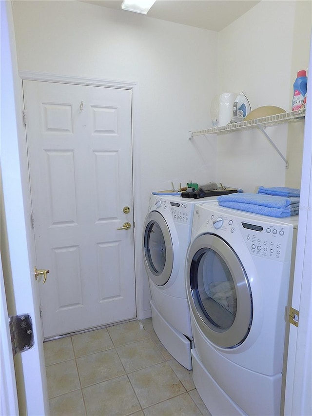 laundry area with light tile patterned floors, laundry area, and washing machine and dryer