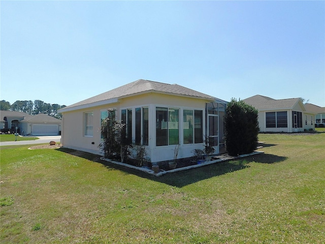 view of side of home featuring a lawn and stucco siding