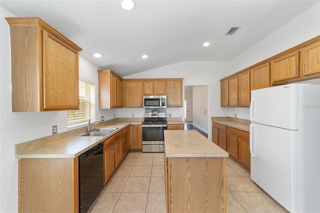 kitchen with visible vents, appliances with stainless steel finishes, a center island, light countertops, and a sink