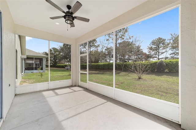 unfurnished sunroom featuring a ceiling fan