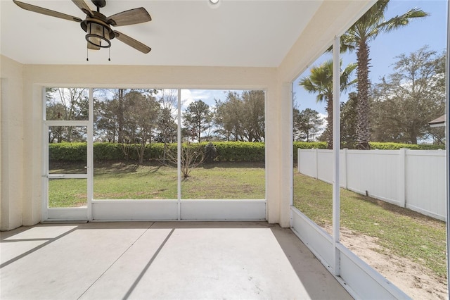 unfurnished sunroom with a ceiling fan