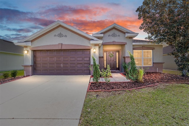 view of front of property featuring driveway, a garage, a front lawn, and stucco siding