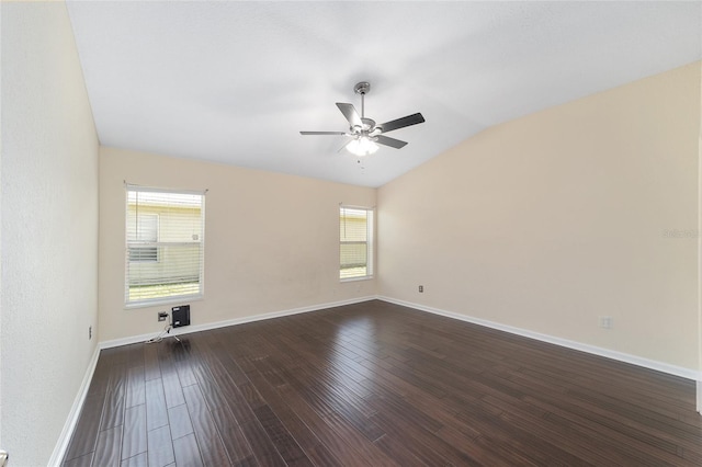 spare room featuring vaulted ceiling, plenty of natural light, dark wood finished floors, and baseboards