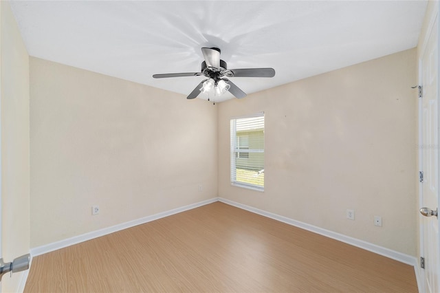 empty room featuring ceiling fan, baseboards, and wood finished floors