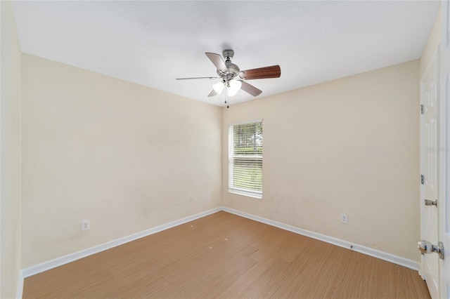 unfurnished room with ceiling fan, wood finished floors, and baseboards