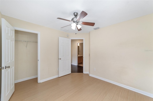 unfurnished bedroom featuring a closet, light wood-type flooring, a ceiling fan, and baseboards