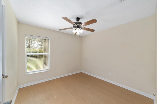 empty room with a ceiling fan, baseboards, and wood finished floors