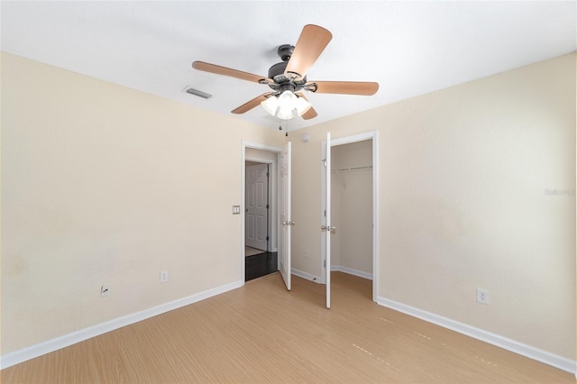 unfurnished bedroom with light wood-style flooring, visible vents, baseboards, and a closet