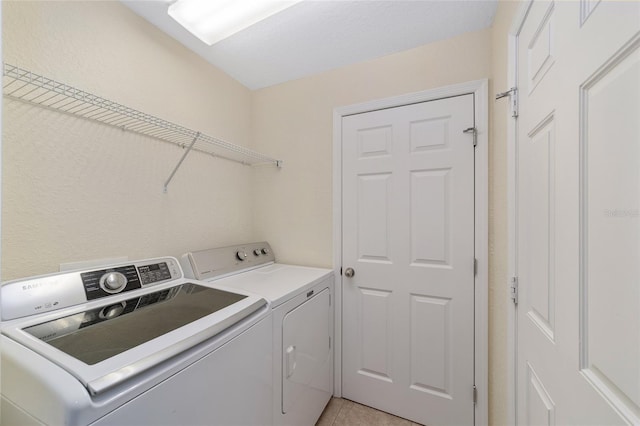 laundry area featuring laundry area, light tile patterned floors, and independent washer and dryer