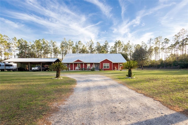 ranch-style house featuring metal roof, driveway, and a front yard