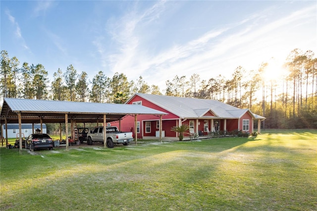 view of front of home with metal roof, a carport, a front yard, and driveway