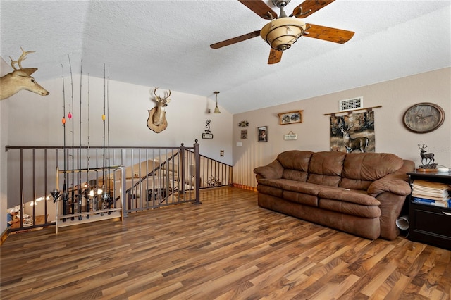 living room with lofted ceiling, visible vents, a textured ceiling, and wood finished floors