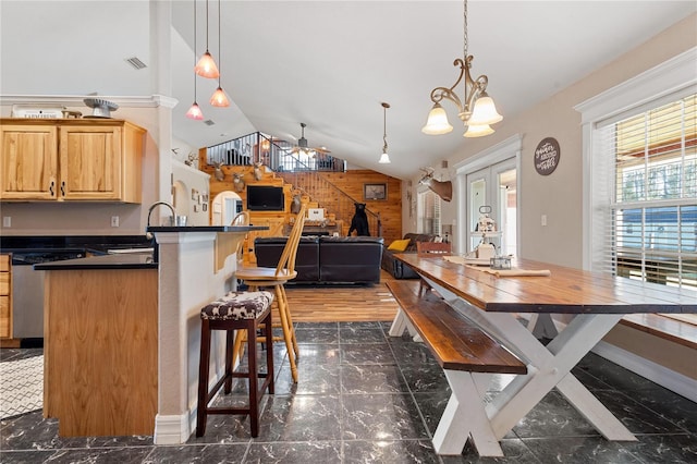 kitchen with marble finish floor, decorative light fixtures, dark countertops, open floor plan, and a kitchen breakfast bar