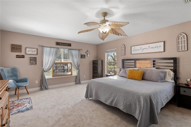 bedroom featuring ceiling fan, baseboards, and light colored carpet