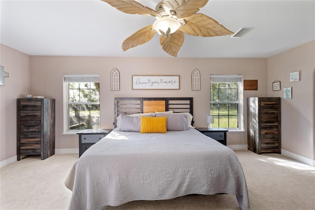 bedroom featuring light carpet, visible vents, and multiple windows