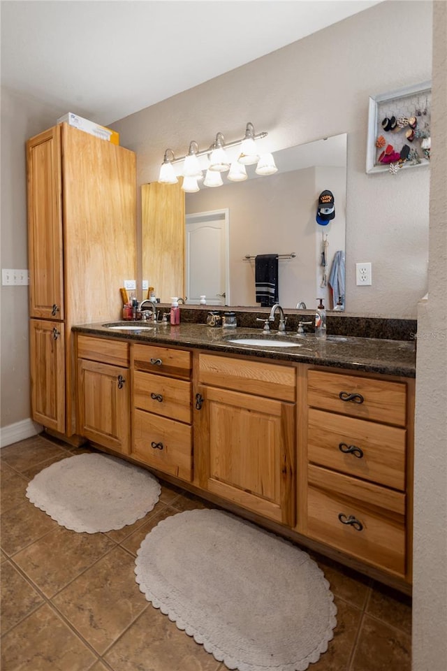 full bath with double vanity, a sink, and tile patterned floors