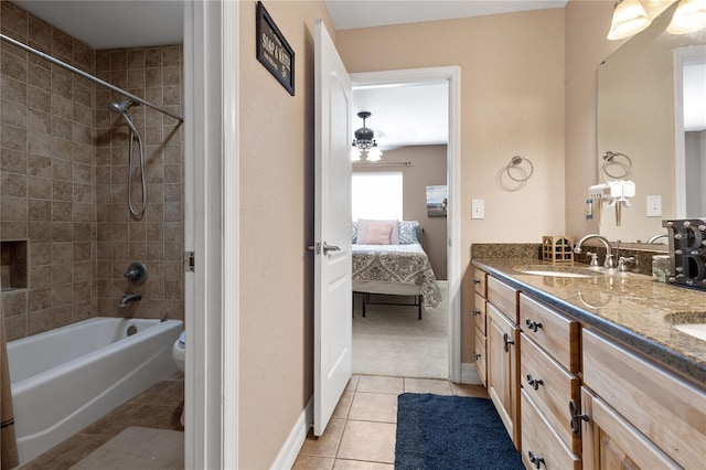 ensuite bathroom with double vanity, connected bathroom, shower / tub combination, tile patterned flooring, and a sink