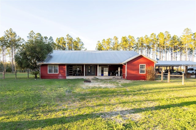 exterior space with fence, metal roof, and a yard