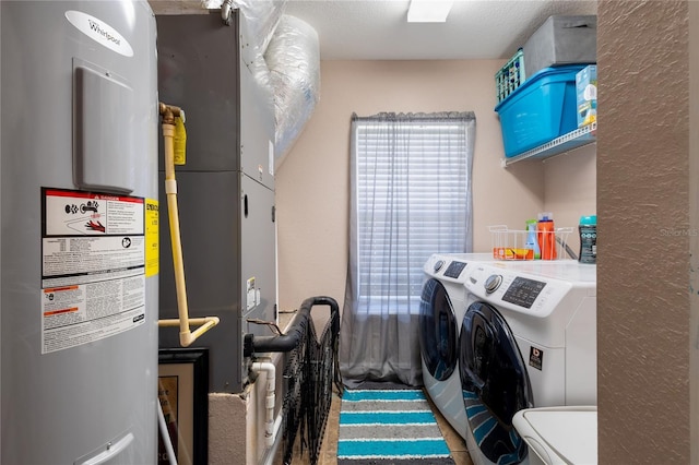 washroom with laundry area, water heater, and separate washer and dryer